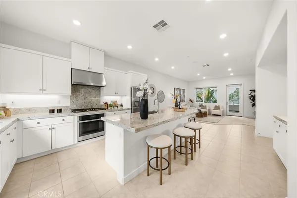 a kitchen with stainless steel appliances kitchen island granite countertop a sink and cabinets