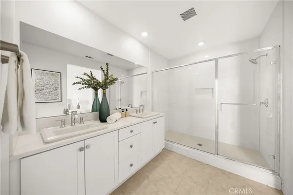 a bathroom with a double vanity sink mirror and shower