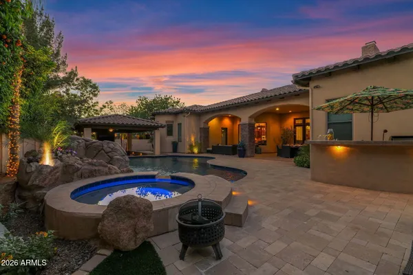 a view of a patio with table and chairs with plants and wooden fence