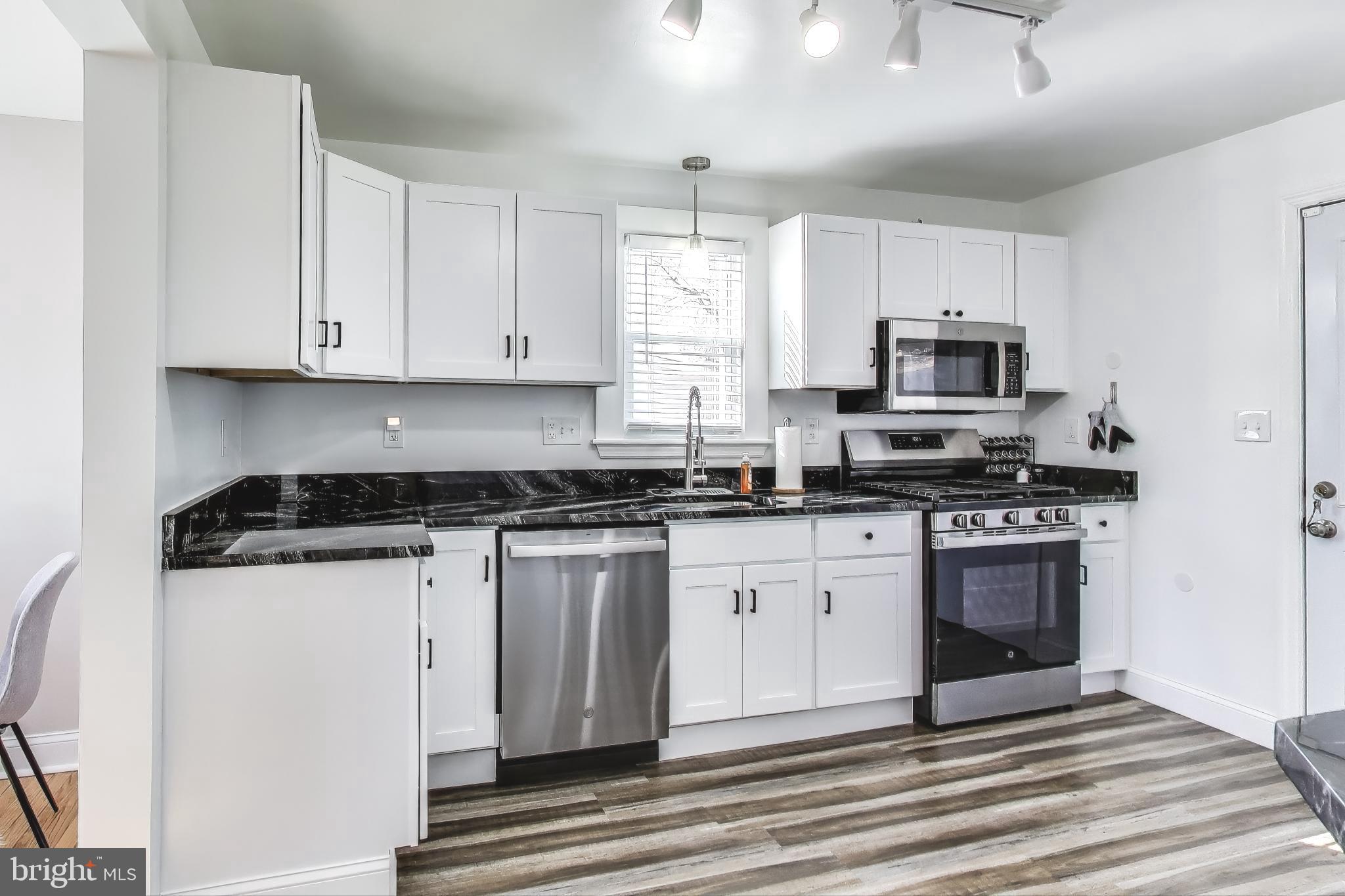 1225 Landover Road Rosedale, MD 21237 - Photo 2 of 48 a kitchen with granite countertop a stove a sink and a microwave