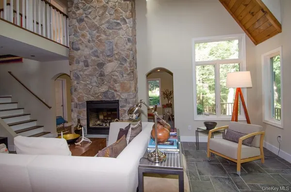 a living room with furniture a fireplace and a potted plant