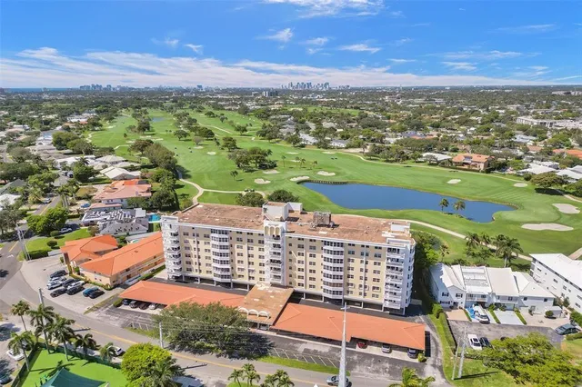 an aerial view of a residential houses with outdoor space and trees