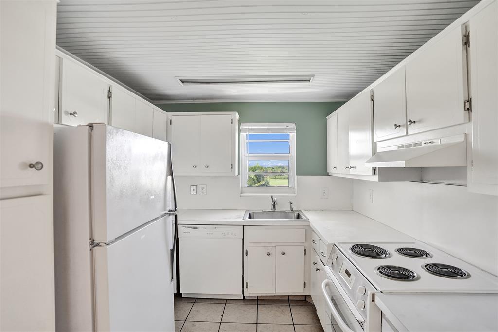 2500 Northeast 48th Lane, Unit 403 Fort Lauderdale, FL 33308 - Photo 6 of 24 a kitchen with a refrigerator a sink and cabinets