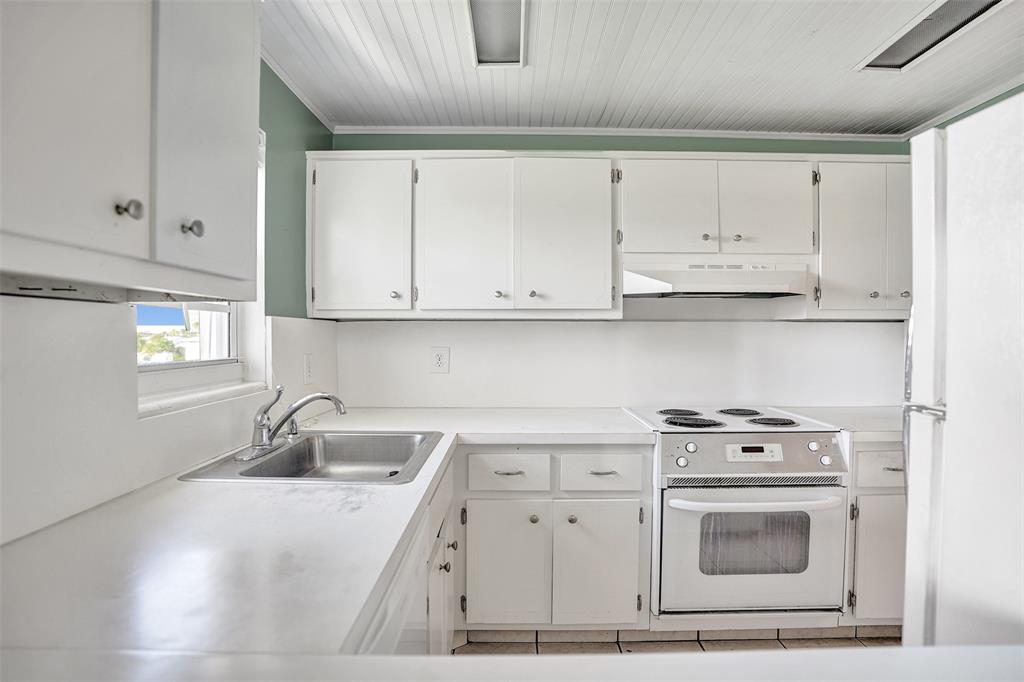 2500 Northeast 48th Lane, Unit 403 Fort Lauderdale, FL 33308 - Photo 8 of 24 a kitchen with a sink a stove and cabinets