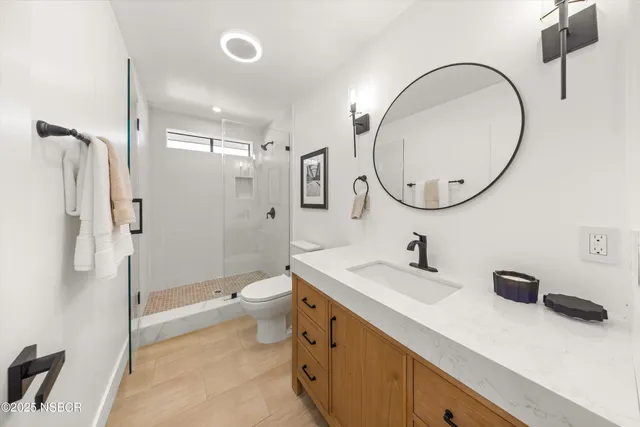 a spacious bathroom with a sink a toilet and a mirror