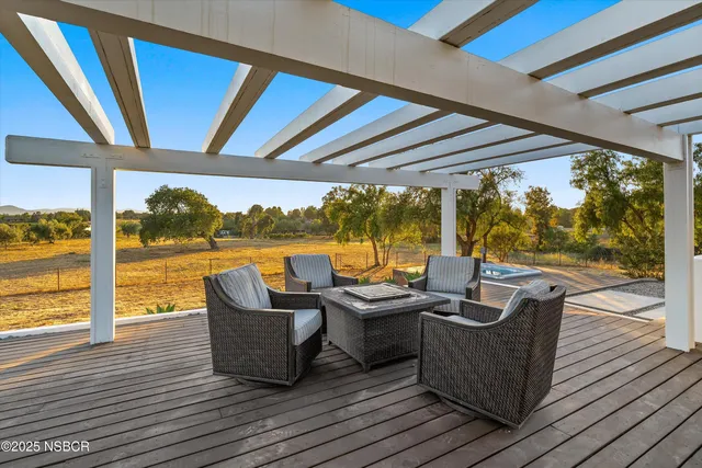 a living room with patio furniture and wooden floor