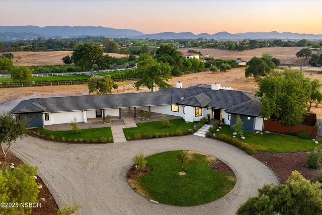 an aerial view of a house with outdoor space and a swimming pool