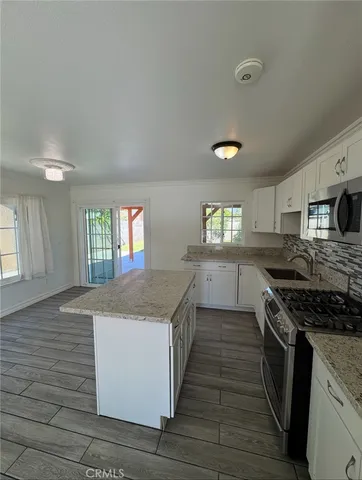 a kitchen with granite countertop a stove and a sink
