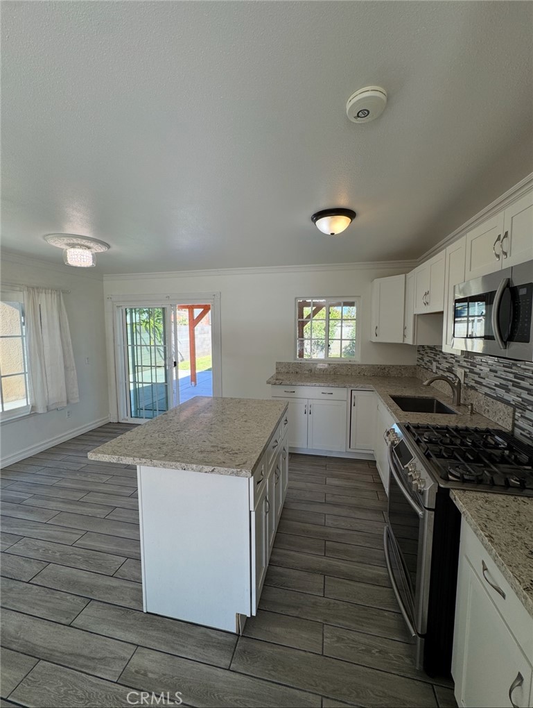 a kitchen with granite countertop a stove and a sink