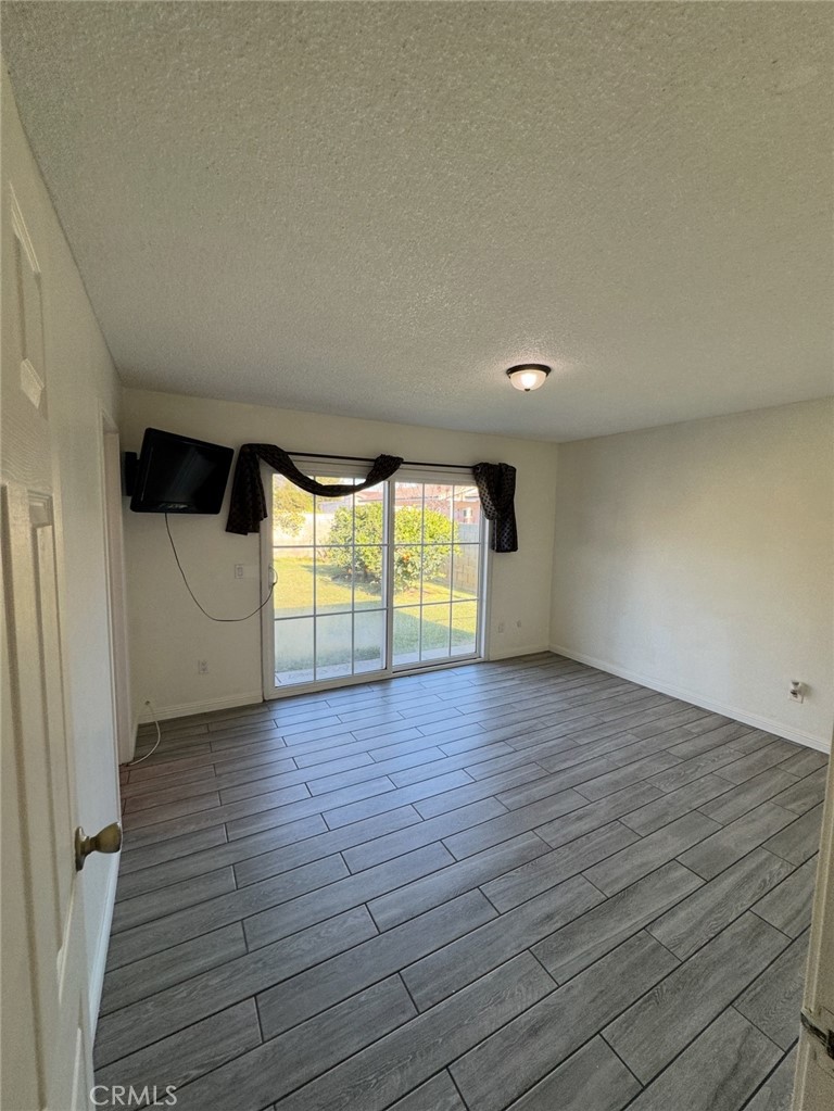 7627 Key W Drive Riverside, CA 92503 - Photo 4 of 7 an empty room with wooden floor and windows