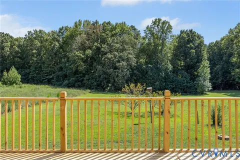 a view of balcony with wooden floor and fence and a yard