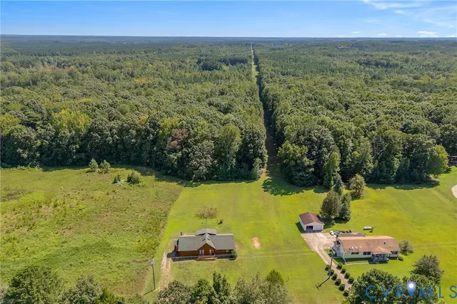 an aerial view of residential houses with outdoor space and trees