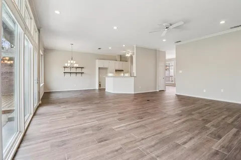 a view of a big room with wooden floor and windows