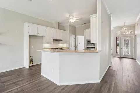 a kitchen with kitchen island white cabinets and stainless steel appliances