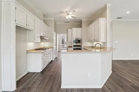 a kitchen with kitchen island white cabinets and refrigerator