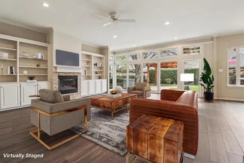 a living room with fireplace furniture and a large window