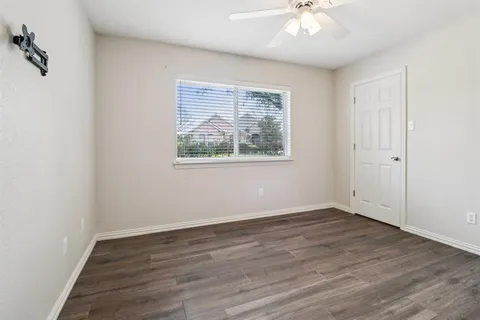 a backyard of a house with plants and large tree