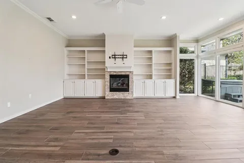an empty room with a fireplace and cabinet