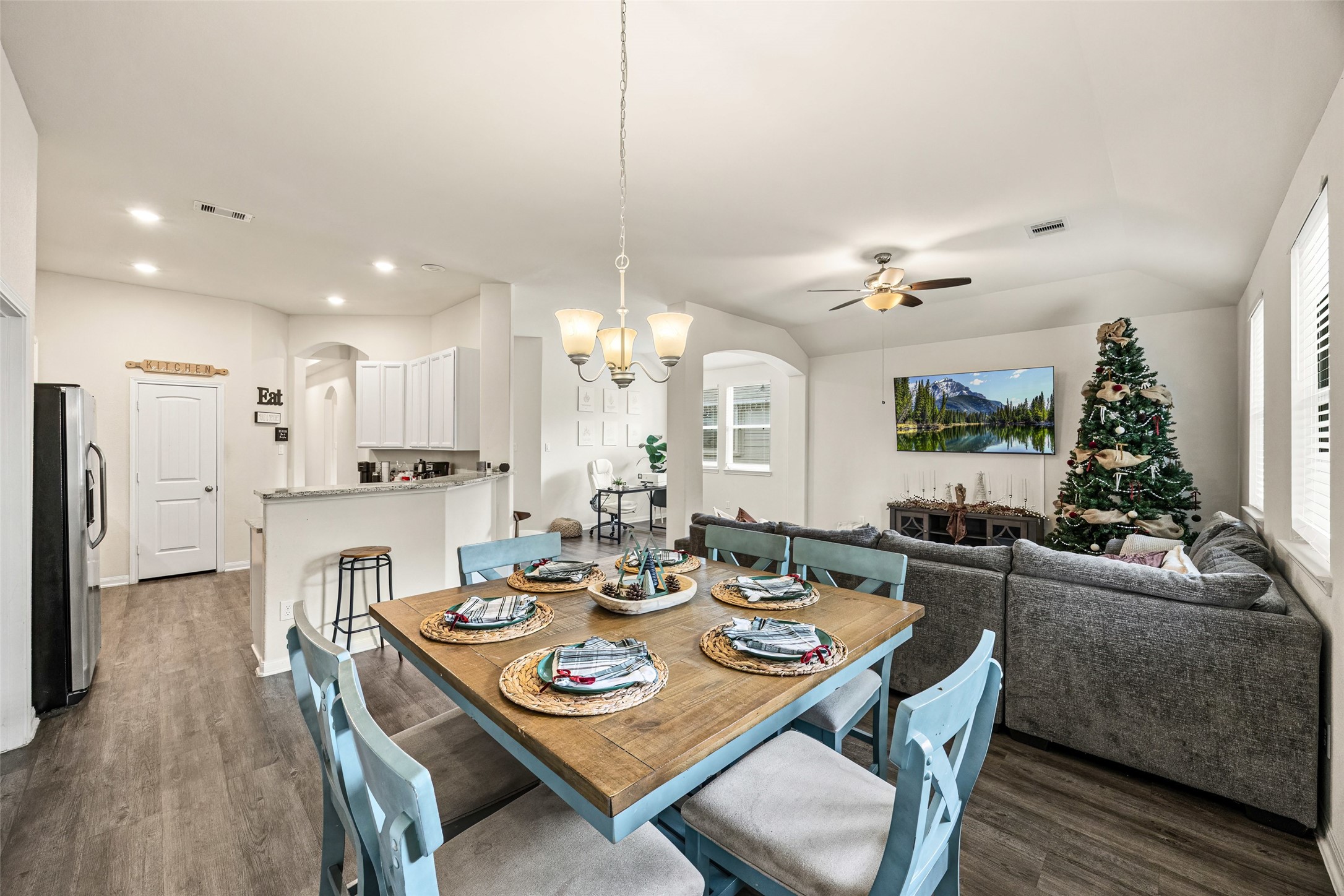 156 County Road Cleveland, TX 77327 - Photo 14 of 25 a view of a dining room and livingroom with furniture wooden floor a rug a fireplace and a chandelier