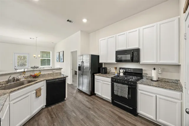 a kitchen with stainless steel appliances a stove sink microwave and refrigerator