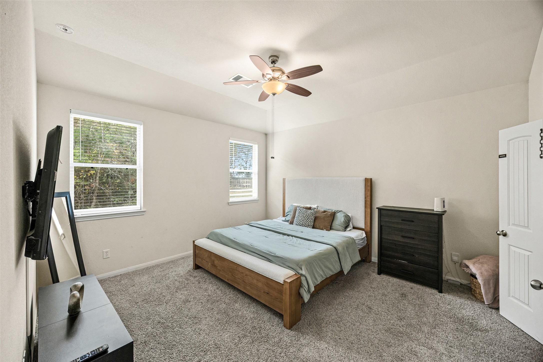 156 County Road Cleveland, TX 77327 - Photo 18 of 25 a bedroom with a bed and a chandelier