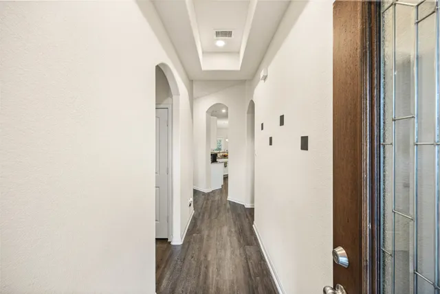 a view of a hallway with wooden floor