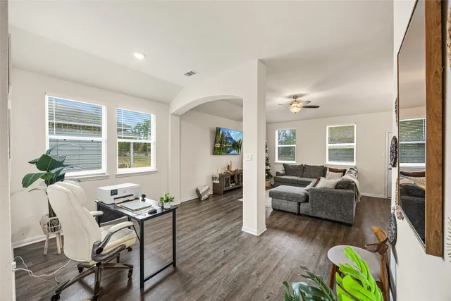 a living room with furniture and a wooden floor