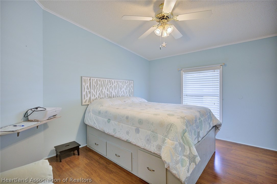 2702 Rodney Street Sebring, FL 33872 - Photo 12 of 33 a bedroom with a bed and a chandelier