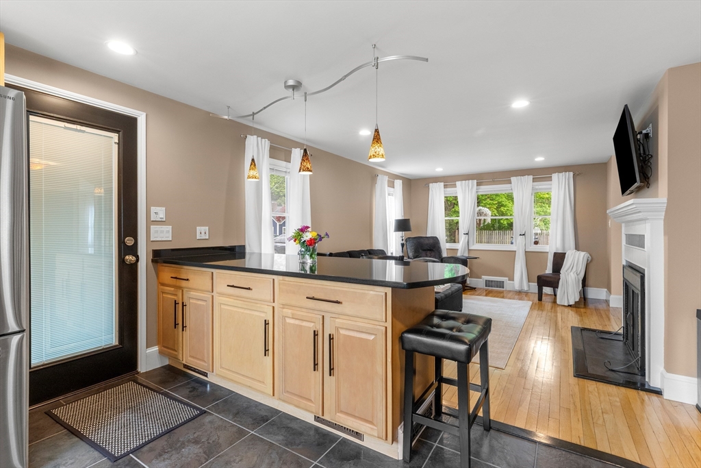 21 Leggs Hill Road Marblehead, MA 01945 - Photo 8 of 38 a kitchen with stainless steel appliances kitchen island granite countertop a stove a sink a dining table and chairs with wooden floor