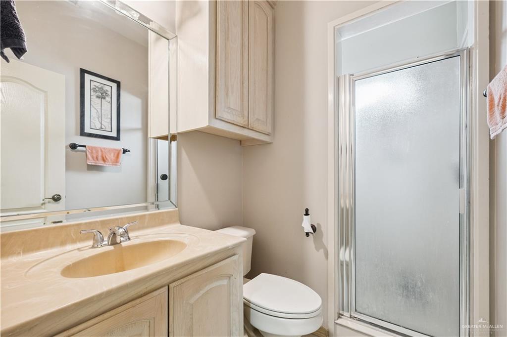 2005 East 28th Street Mission, TX 78574 - Photo 17 of 28 a bathroom with a granite countertop sink toilet and shower