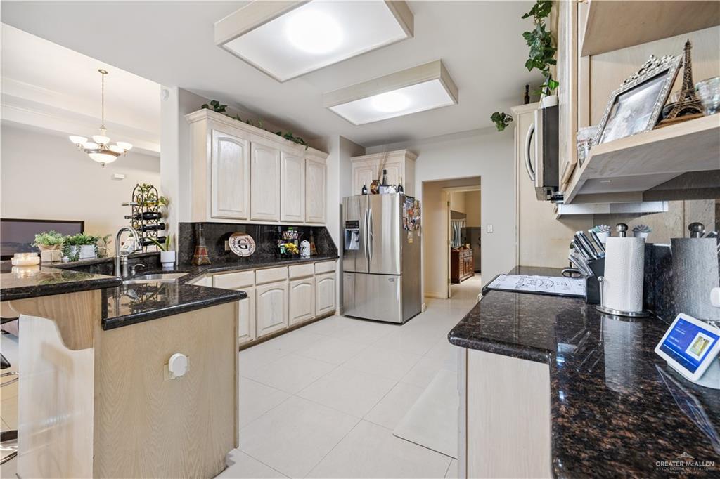 2005 East 28th Street Mission, TX 78574 - Photo 7 of 28 a kitchen with granite countertop a sink stainless steel appliances and white cabinets