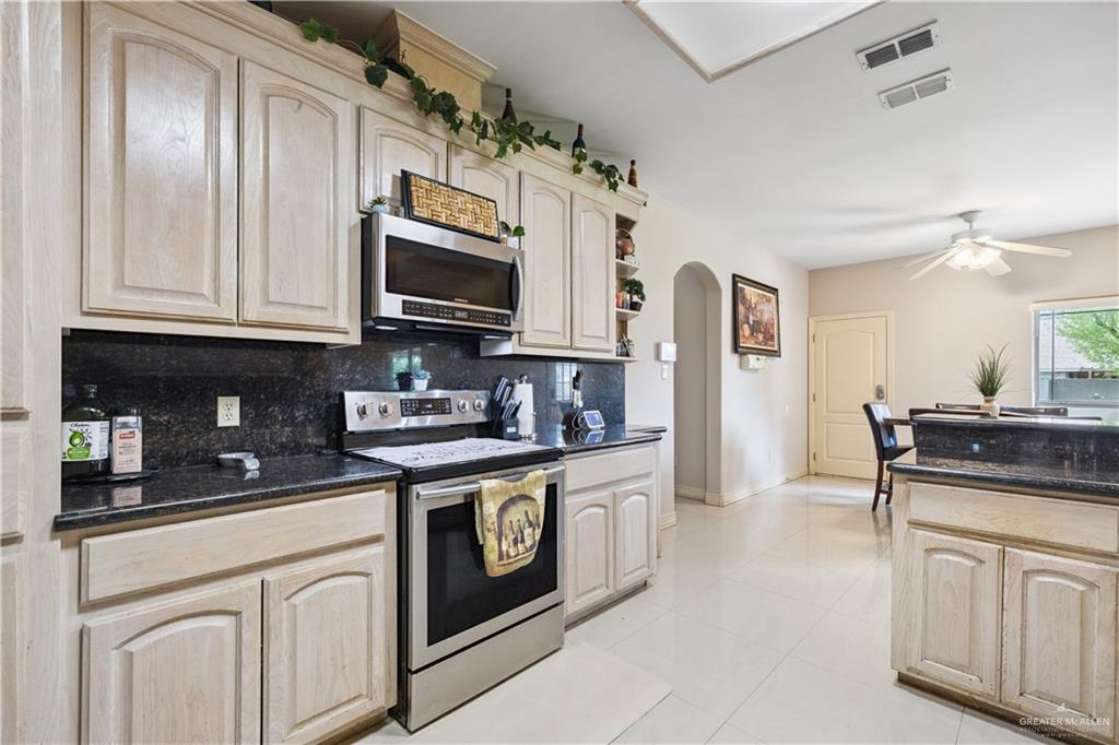 2005 East 28th Street Mission, TX 78574 - Photo 8 of 28 a kitchen with stainless steel appliances granite countertop a stove a sink and a microwave