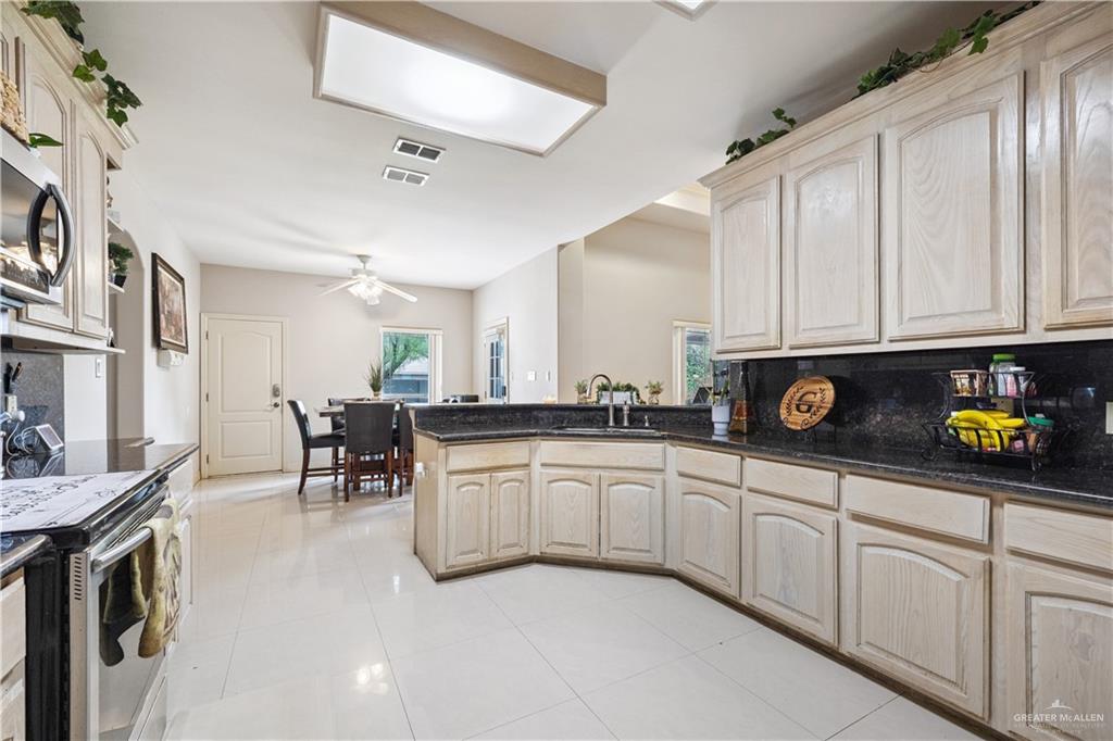 2005 East 28th Street Mission, TX 78574 - Photo 9 of 28 a kitchen with white cabinets and sink