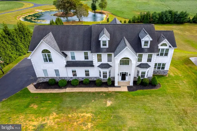 an aerial view of residential houses with yard and lake view