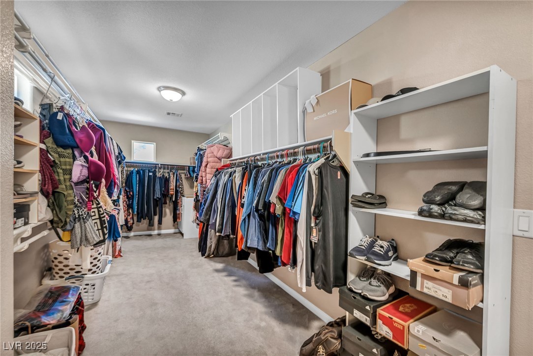 8929 Glenistar Gate Avenue Las Vegas, NV 89143 - Photo 49 of 96 HUGE Primary Suite walk in closet boasts custom shelves, and ample amount of storage space.
