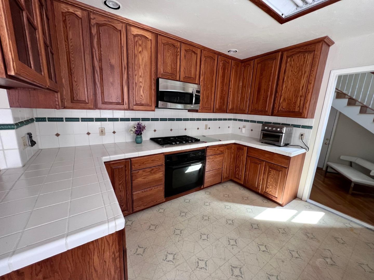 14004 Clayton Road San Jose, CA 95127 - Photo 6 of 43 a kitchen with stainless steel appliances granite countertop wooden cabinets a stove top oven a sink and dishwasher
