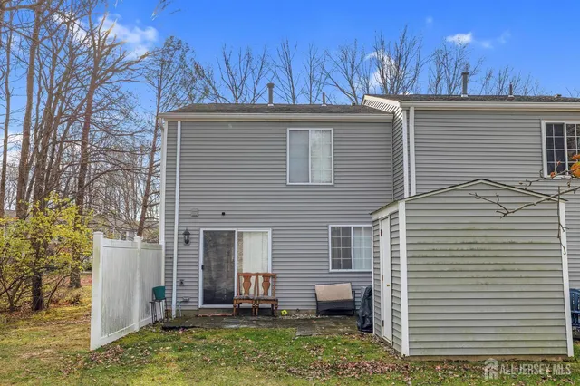 a view of a house with a yard and lawn chairs under an umbrella