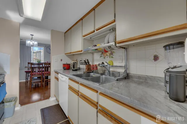 a kitchen with granite countertop a sink a stove and cabinets