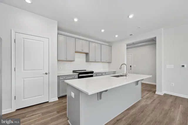 a view of kitchen with kitchen island white cabinets wooden floor and center island