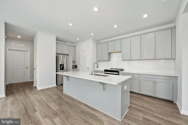 a kitchen with granite countertop a sink stainless steel appliances and cabinets