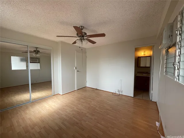a view of an empty room with closet and a window