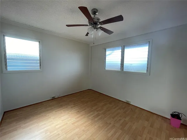 an empty room with a window and a ceiling fan