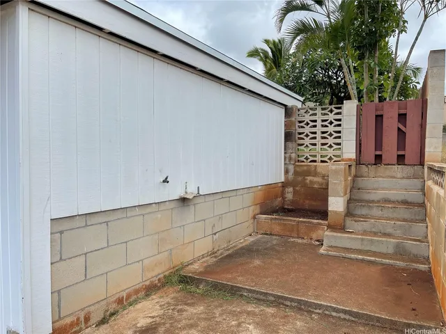 a backyard of a house with barbeque oven and brick wall
