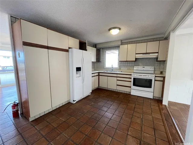 a kitchen with stainless steel appliances a refrigerator sink and cabinets