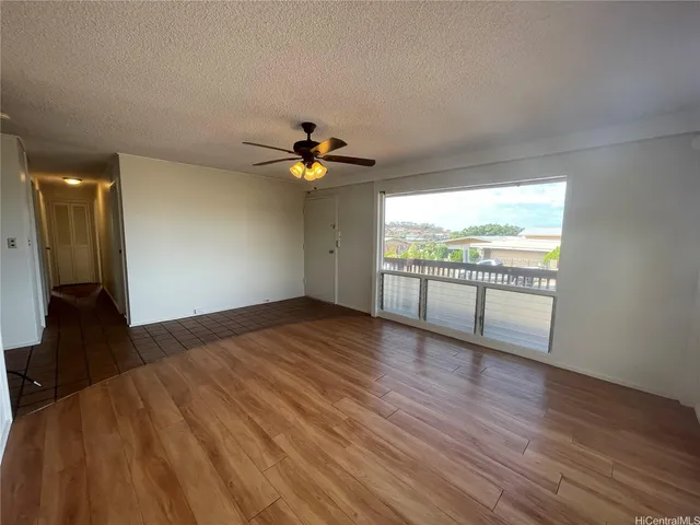 a view of an empty room window and wooden floor