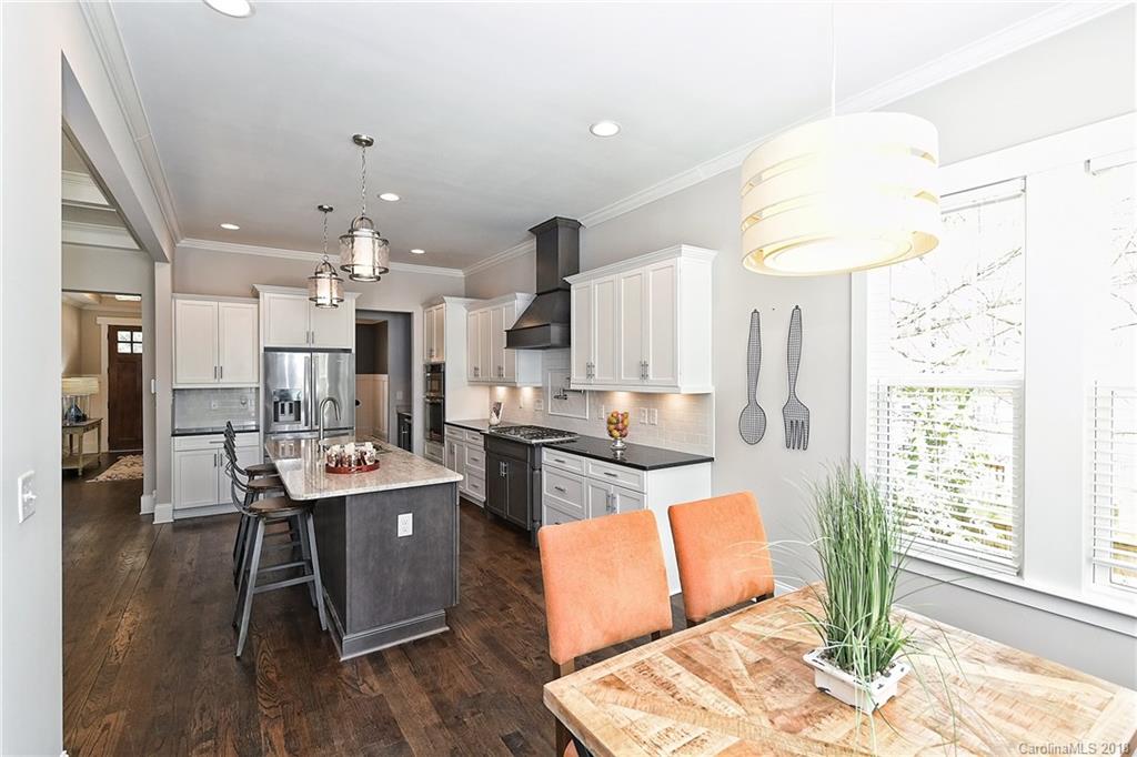 1624 Brook Road Charlotte, NC 28205 - Photo 15 of 34 a kitchen with stainless steel appliances kitchen island granite countertop a refrigerator a stove a sink dishwasher and a dining table with wooden floor