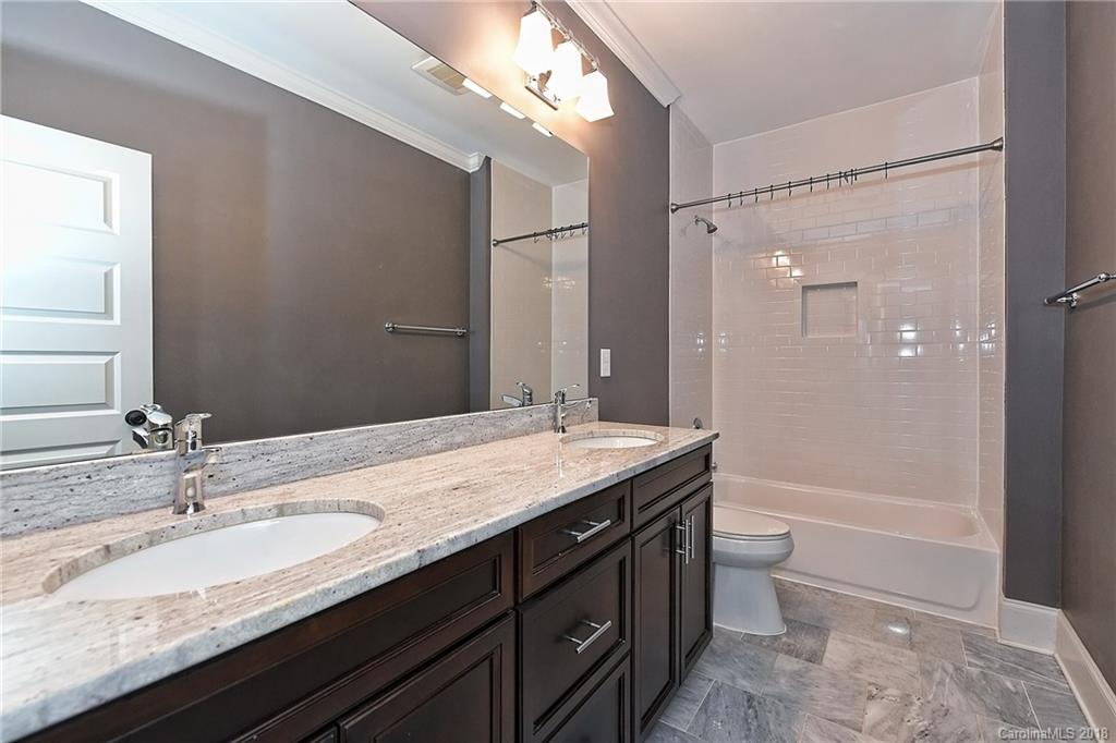 1624 Brook Road Charlotte, NC 28205 - Photo 28 of 34 a bathroom with a granite countertop sink a toilet a large mirror and shower