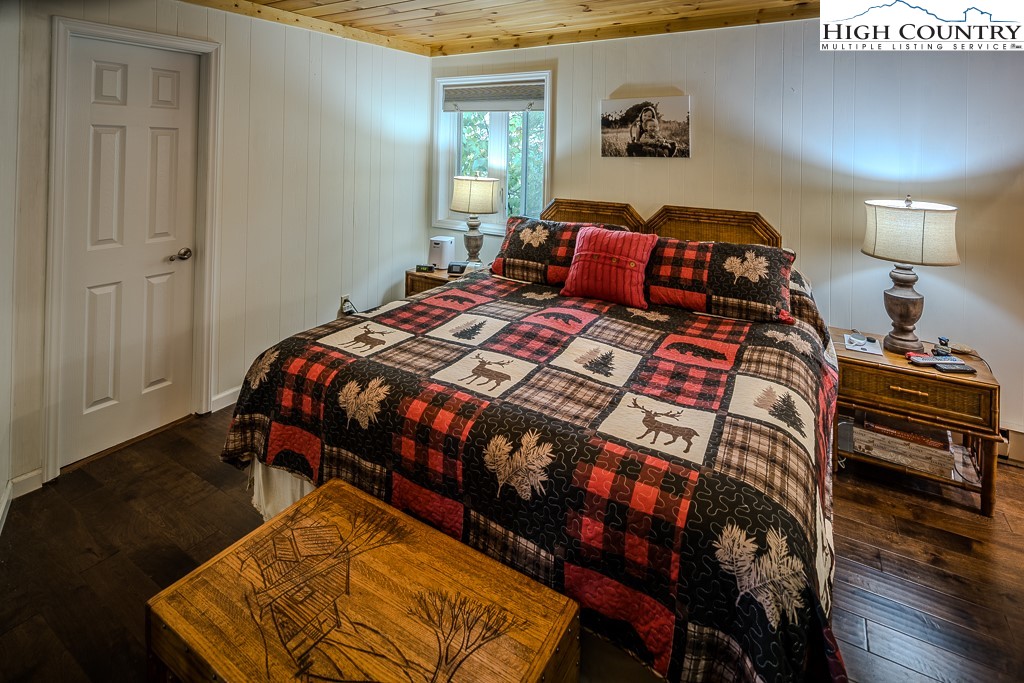 206 Pinnacle Ridge Road Beech Mountain, NC 28604 - Photo 22 of 41 a bedroom with a bed and a lamp on dresser