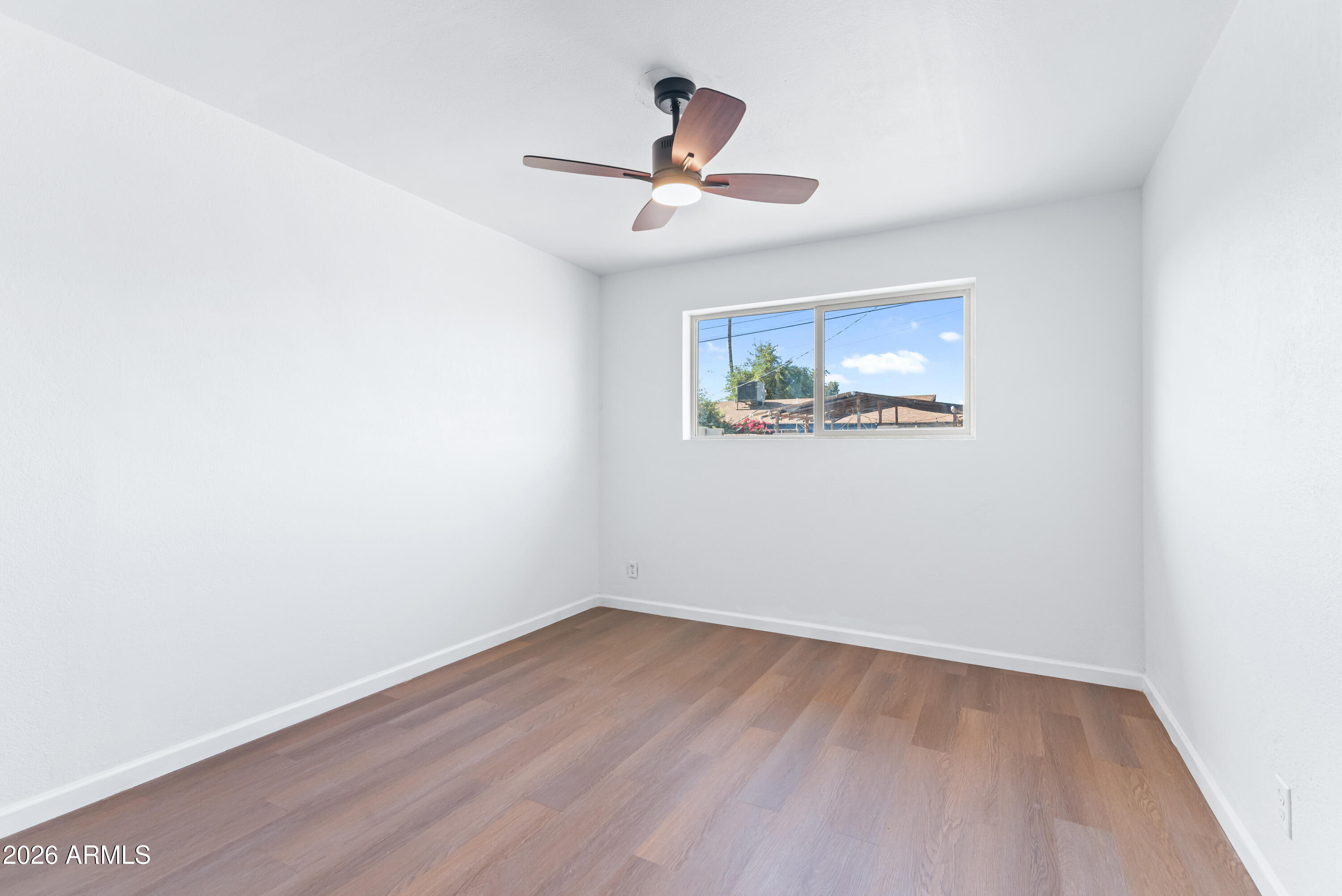 860 West McLellan Road Mesa, AZ 85201 - Photo 16 of 26 an empty room with wooden floor and ceiling fan