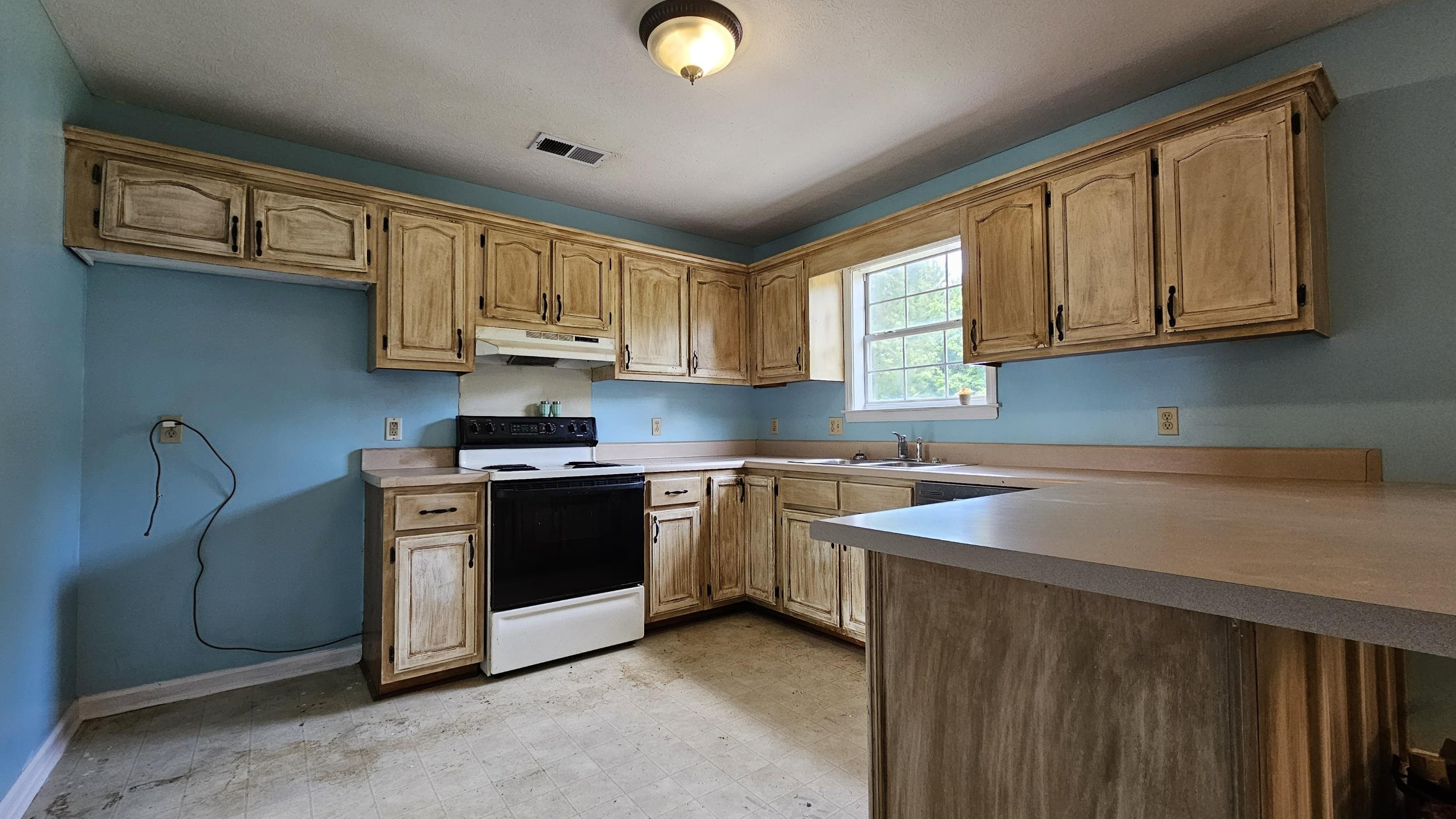 1740 Conner Whitefield Road Ripley, TN 38063 - Photo 6 of 10 a kitchen with stainless steel appliances granite countertop a stove a sink dishwasher and a microwave oven with cabinets